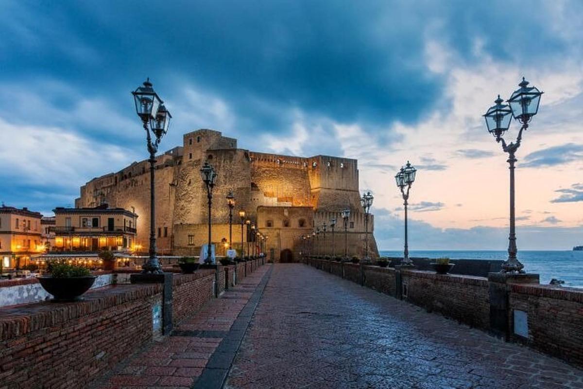 velký hrad stojící za soumraku u oceánu