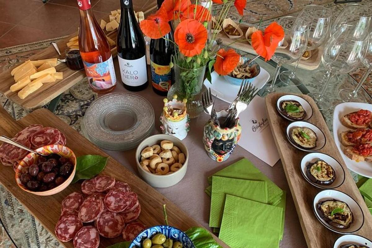 o masă cu o grămadă de mâncare și sticle de vin