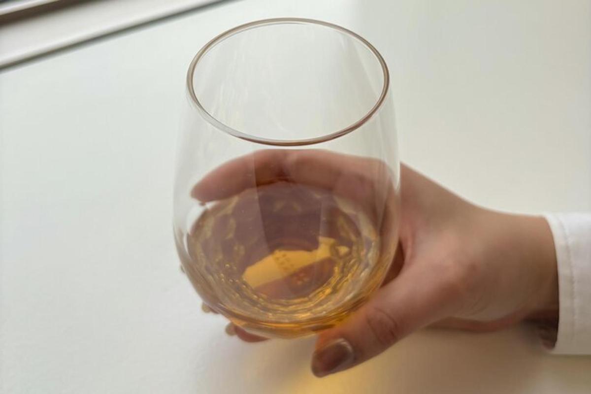 ένα άτομο που κρατάει ένα ποτήρι κρασί στο χέρι του