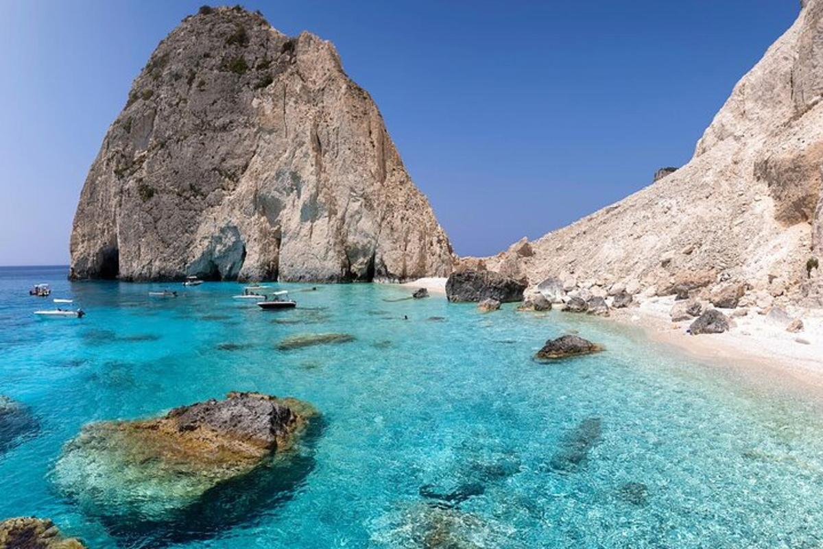 μια παραλία με ένα σωρό βράχια και γαλάζια νερά