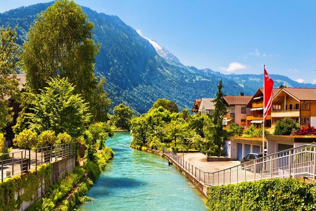 un fiume in una valle con case e una montagna