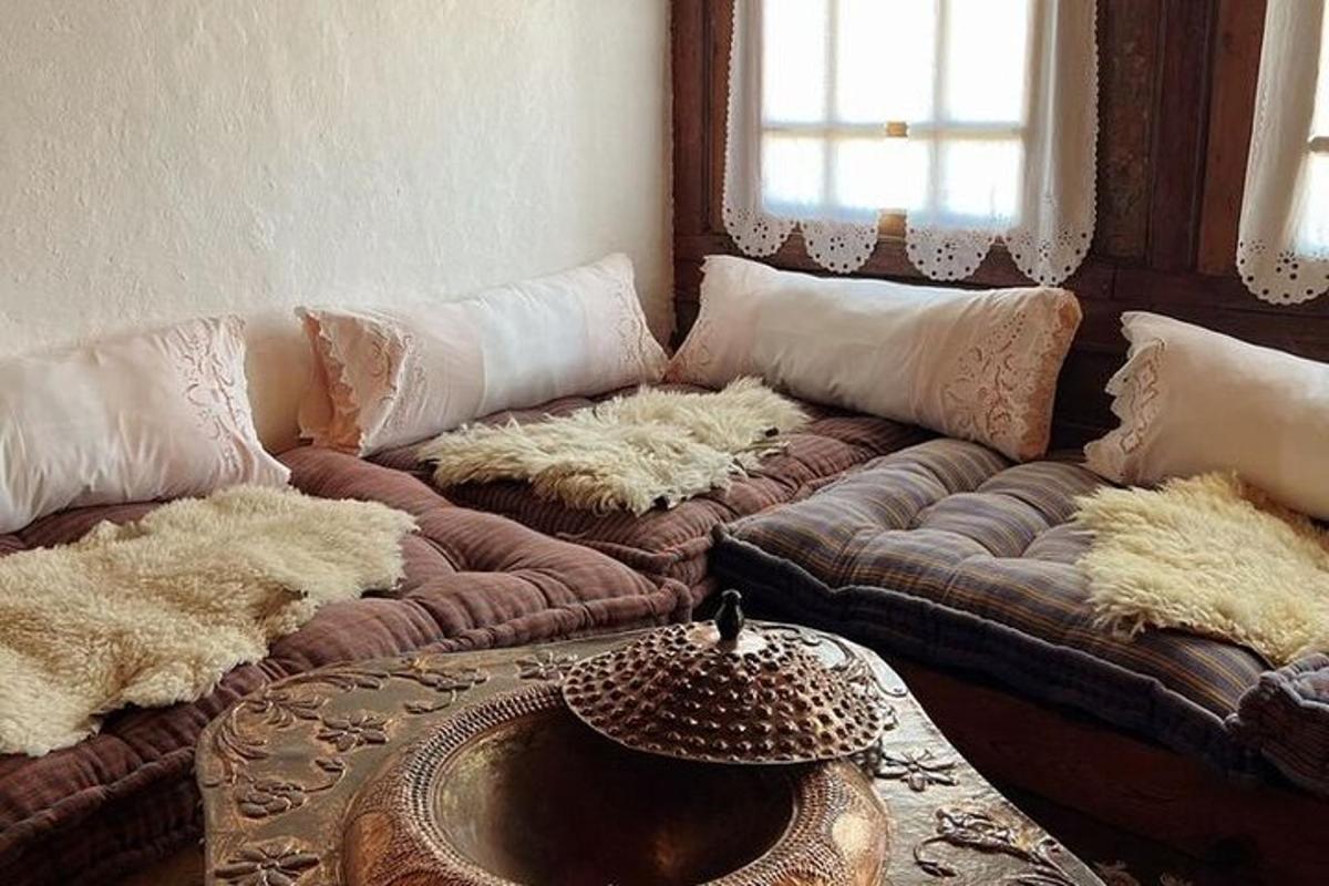 Una sala de estar con un sofá marrón con almohadas blancas.