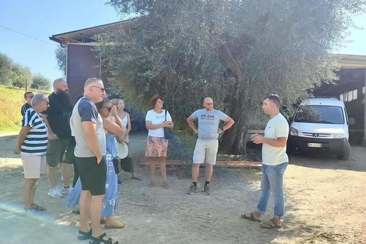 un grupo de personas de pie frente a un árbol