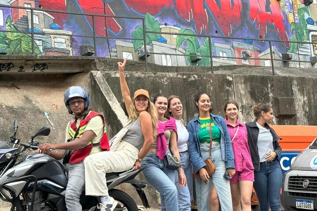 sekumpulan orang duduk di atas motosikal di hadapan dinding