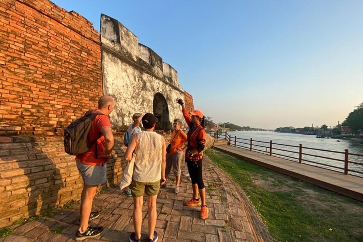 một nhóm người đứng cạnh một bức tường gạch