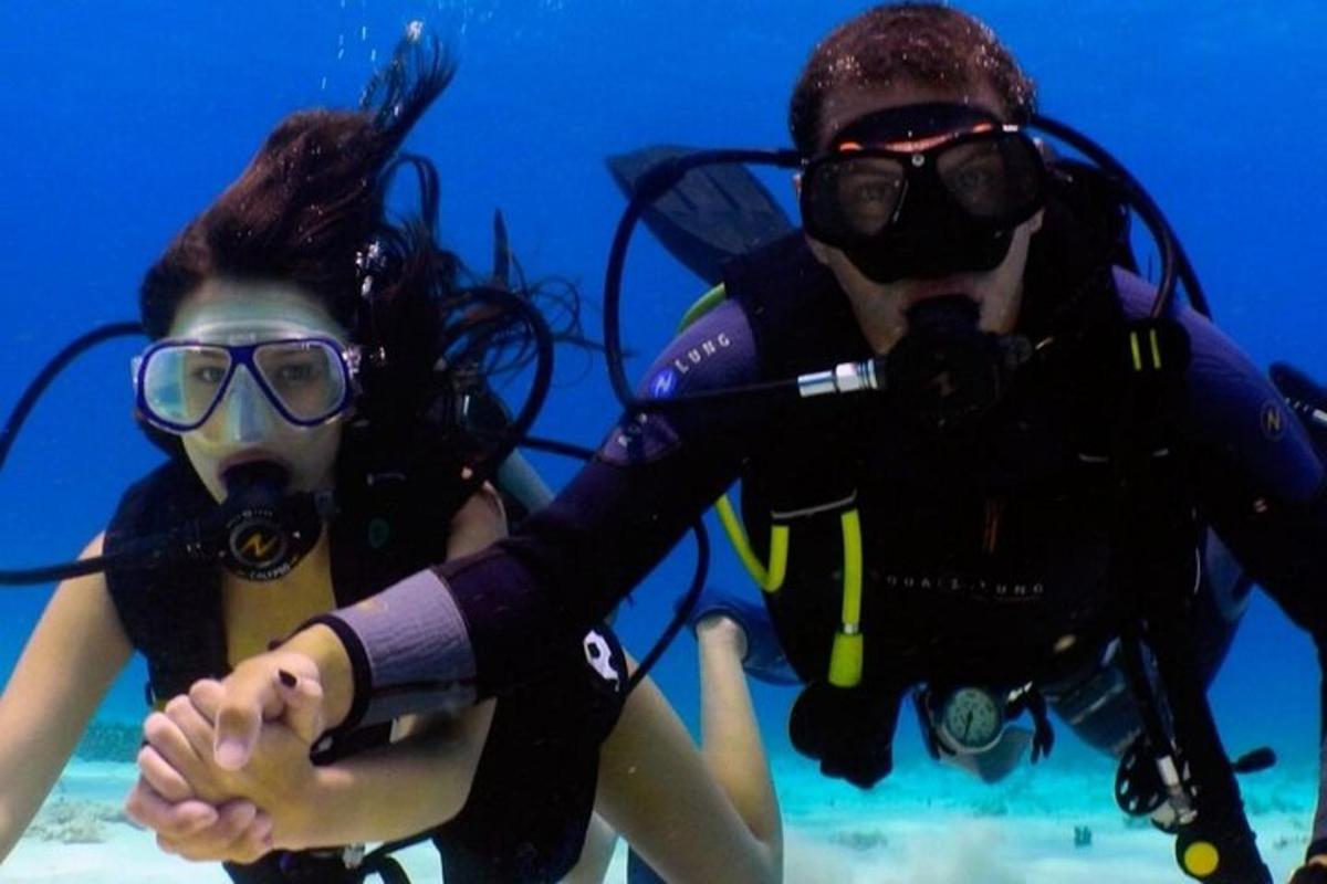 un uomo e una donna in attrezzatura da sub in acqua