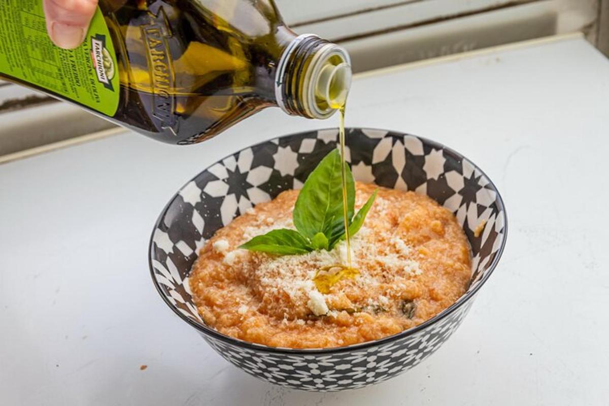 a bottle of wine being poured into a bowl of food