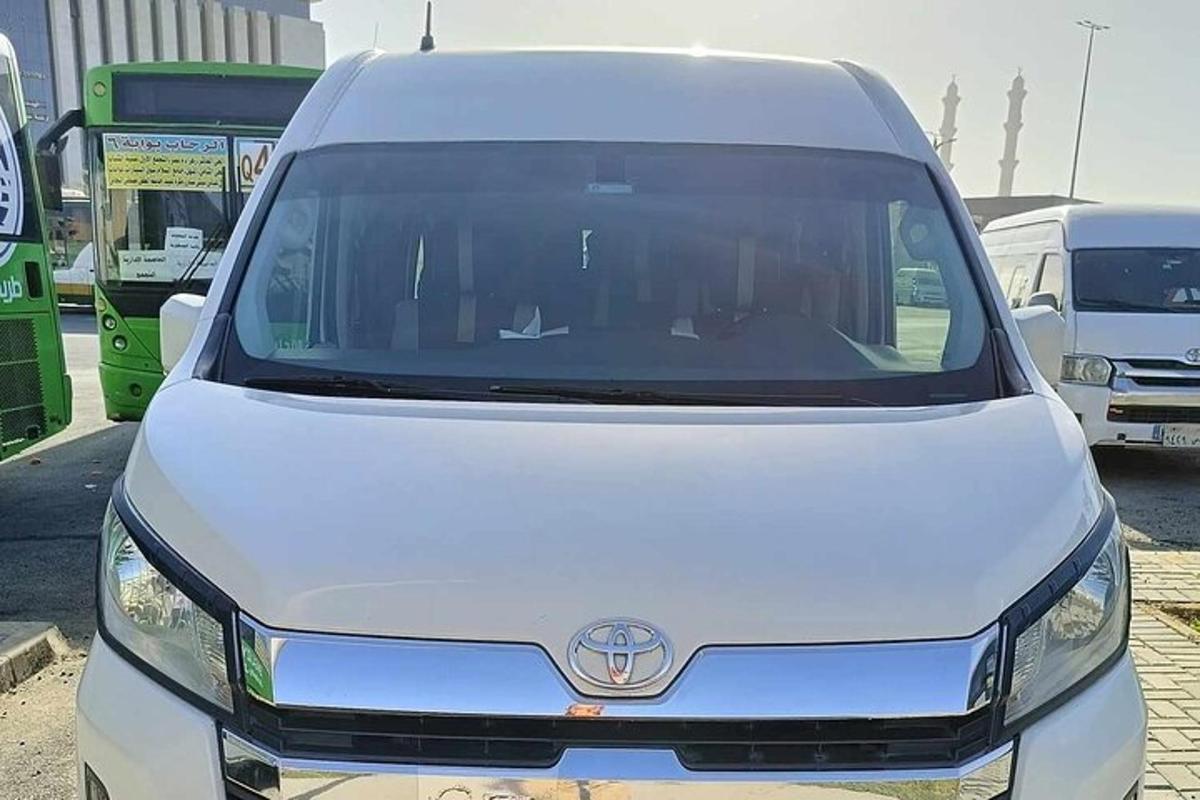 egy fehér furgon parkolt egy buszokkal teli parkolóban