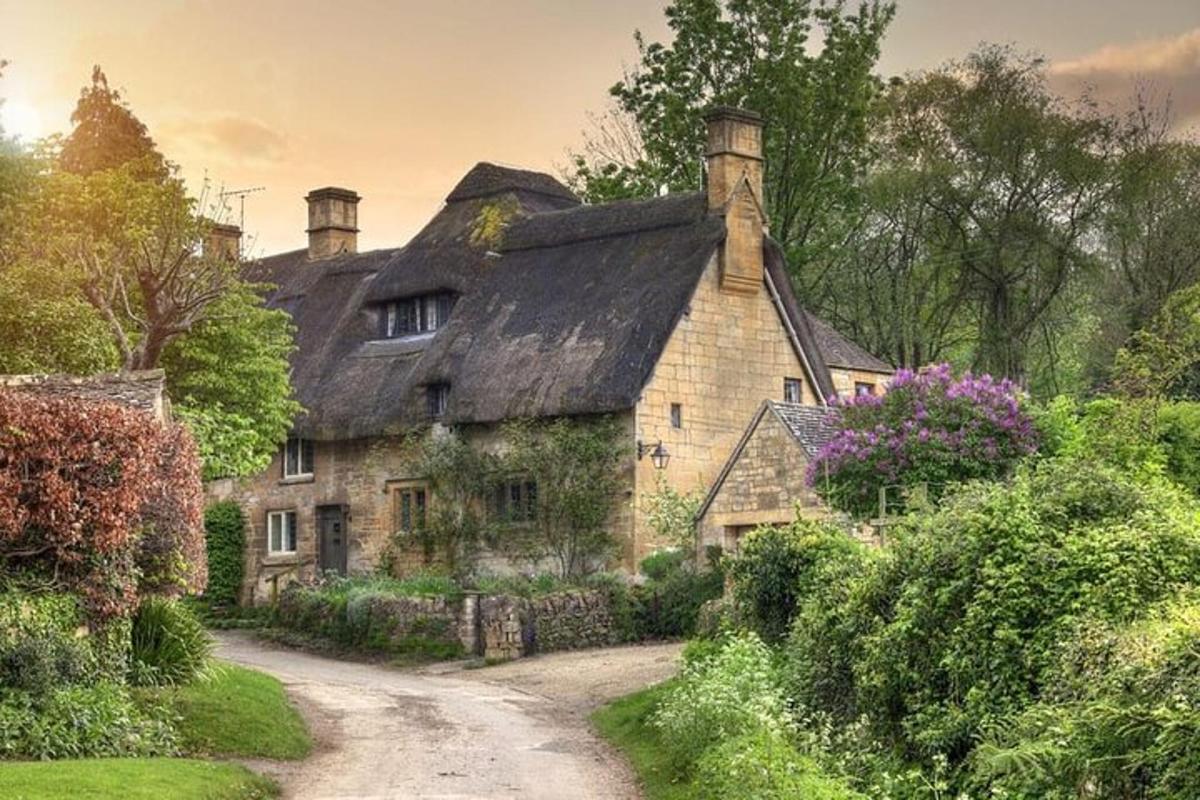 an old stone house in the middle of a dirt road