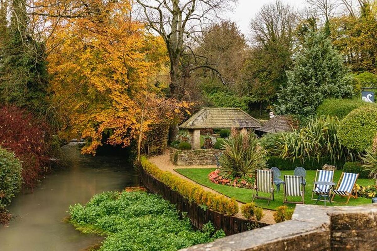 a garden with chairs and a gazebo next to a river