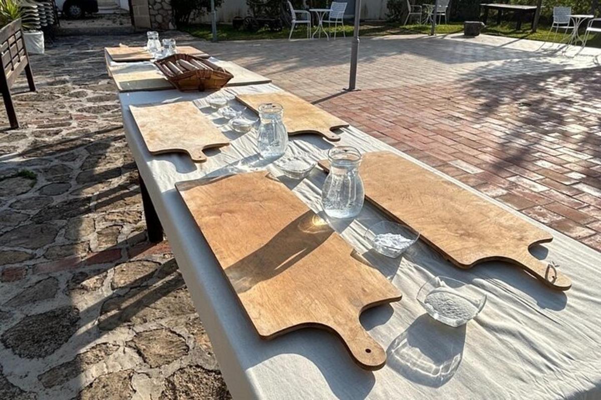 Una larga mesa de madera con vasos y botellas encima.