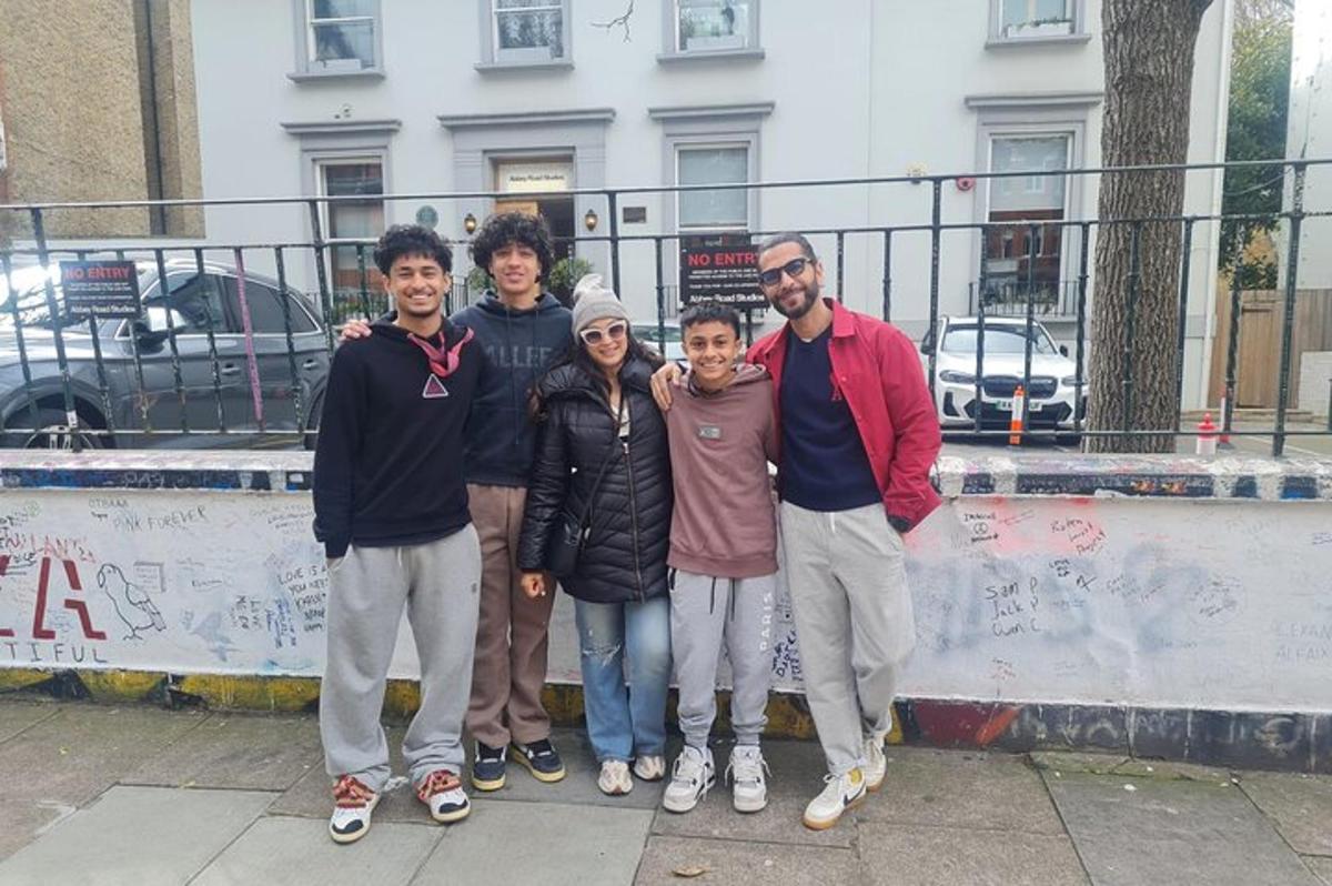 Un grupo de personas de pie junto a una pared