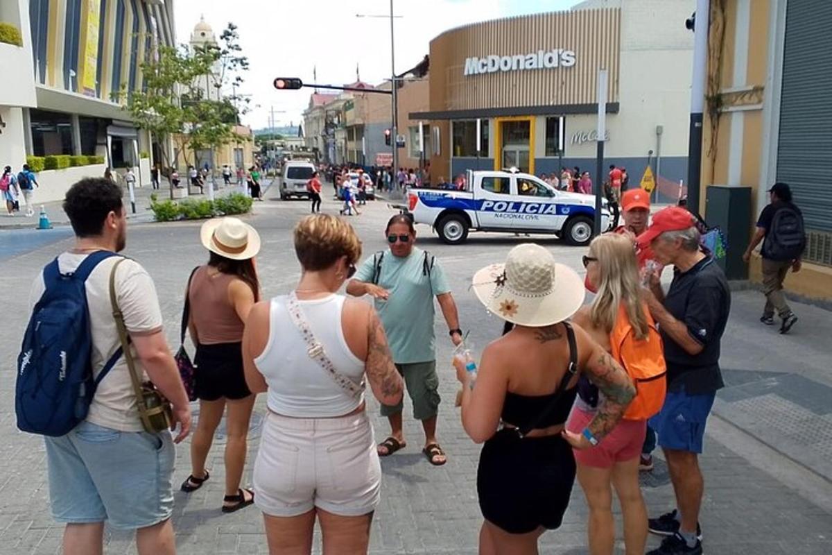 a group of people standing on a street with a police car