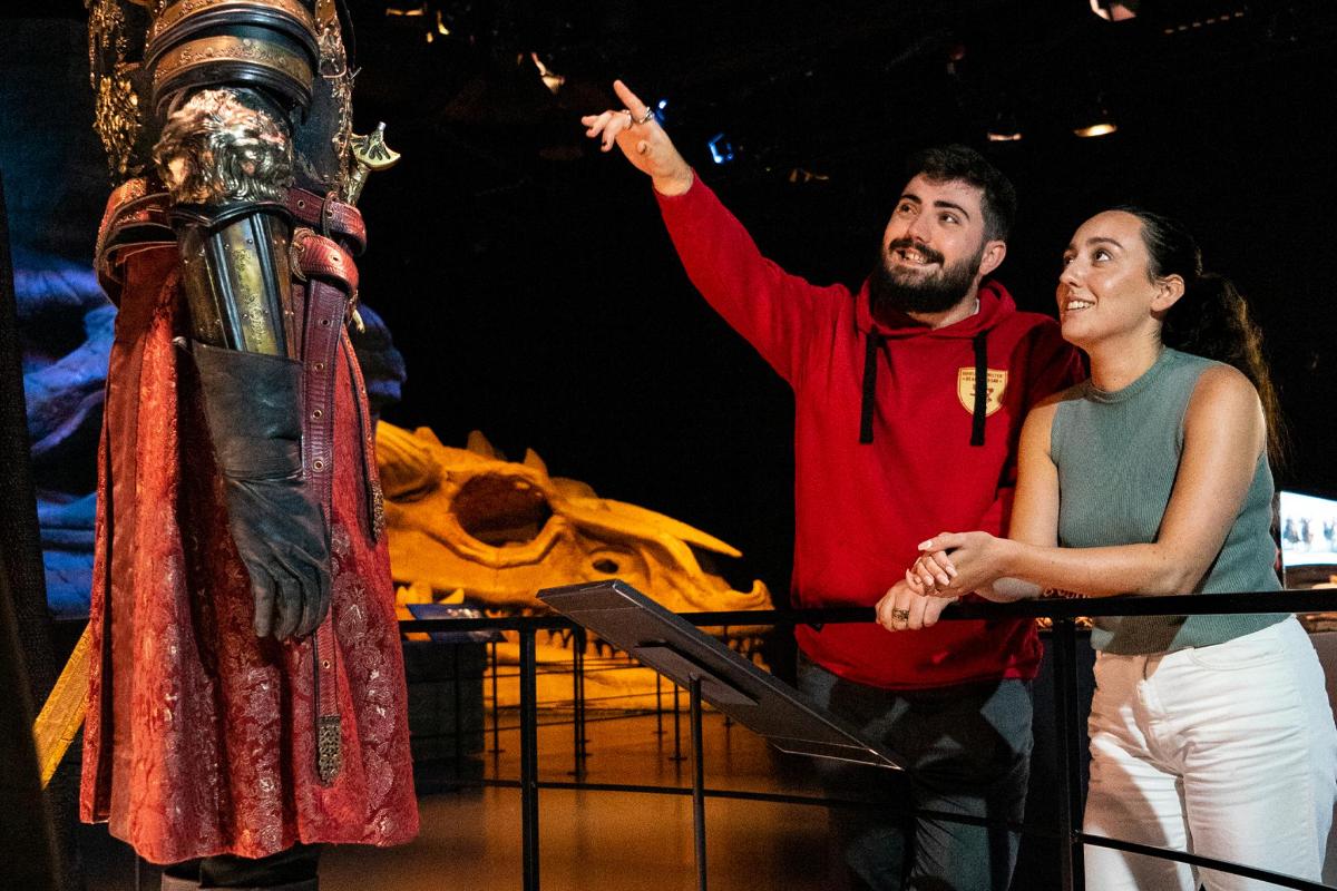 a man and a woman standing next to a statue