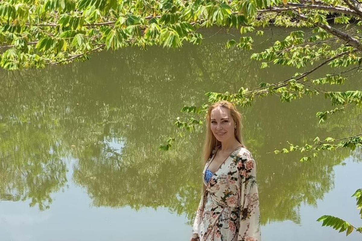 una mujer parada frente a un cuerpo de agua