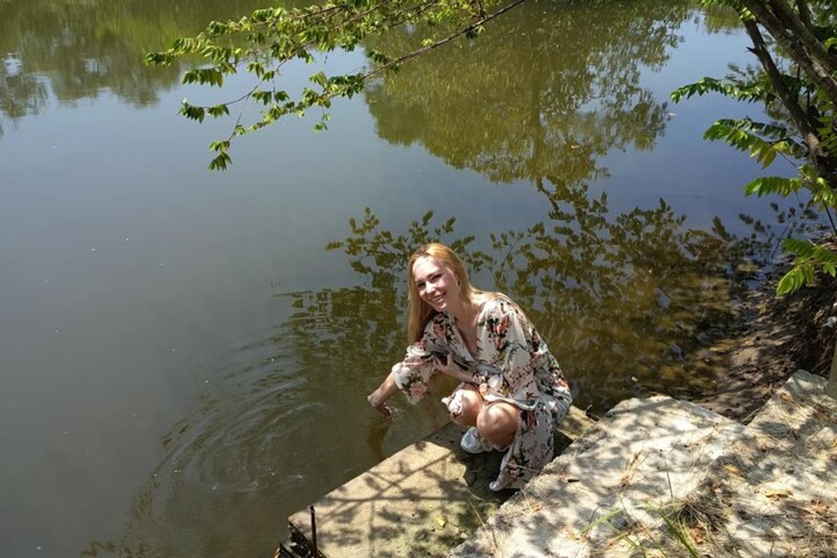 una mujer arrodillada frente a un cuerpo de agua