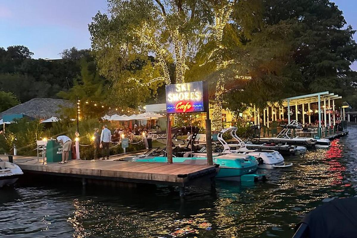Un muelle con barcos atracados en un río con un cartel.