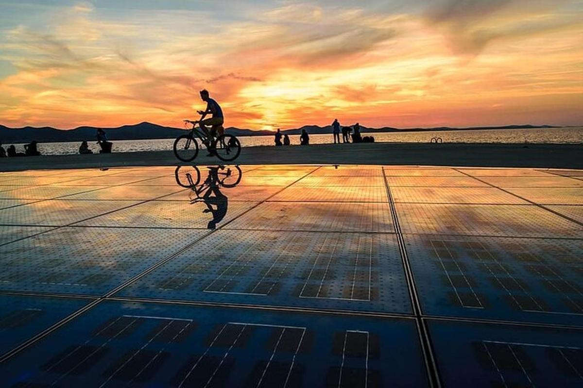 una persona in bicicletta sulla spiaggia al tramonto