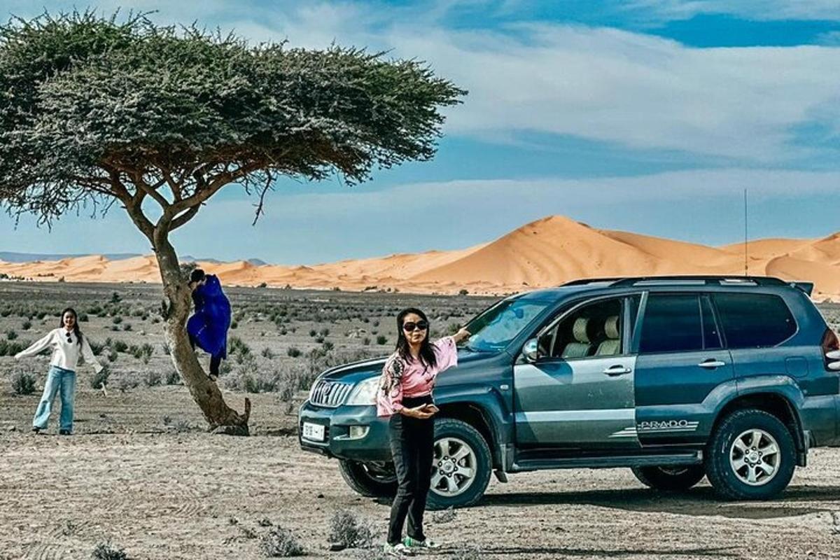 uma mulher parada ao lado de um SUV azul no deserto