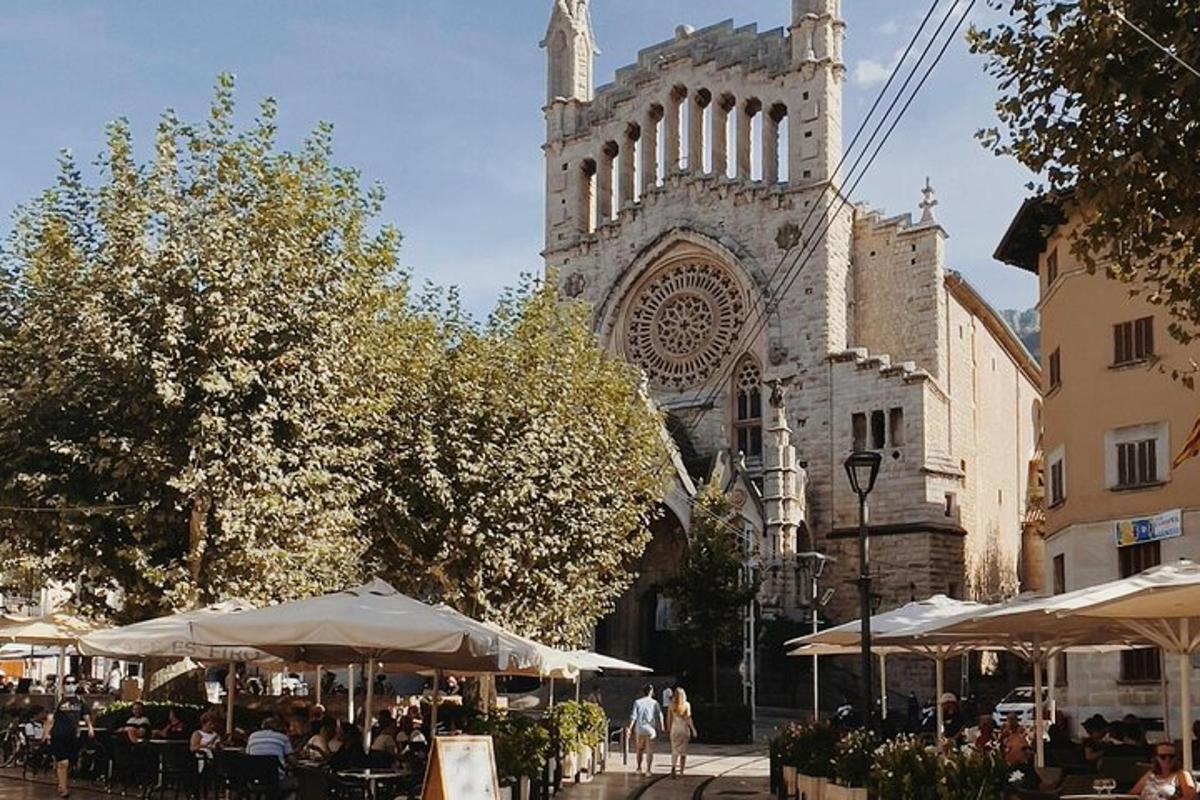 a building with a cathedral with tables and umbrellas