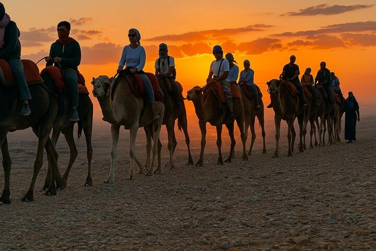 a group of people riding horses on the beach at sunset