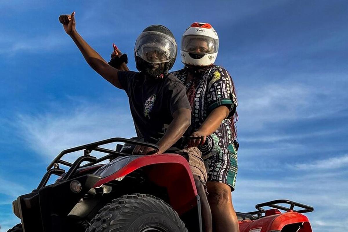 two men on a atv with their hands in the air