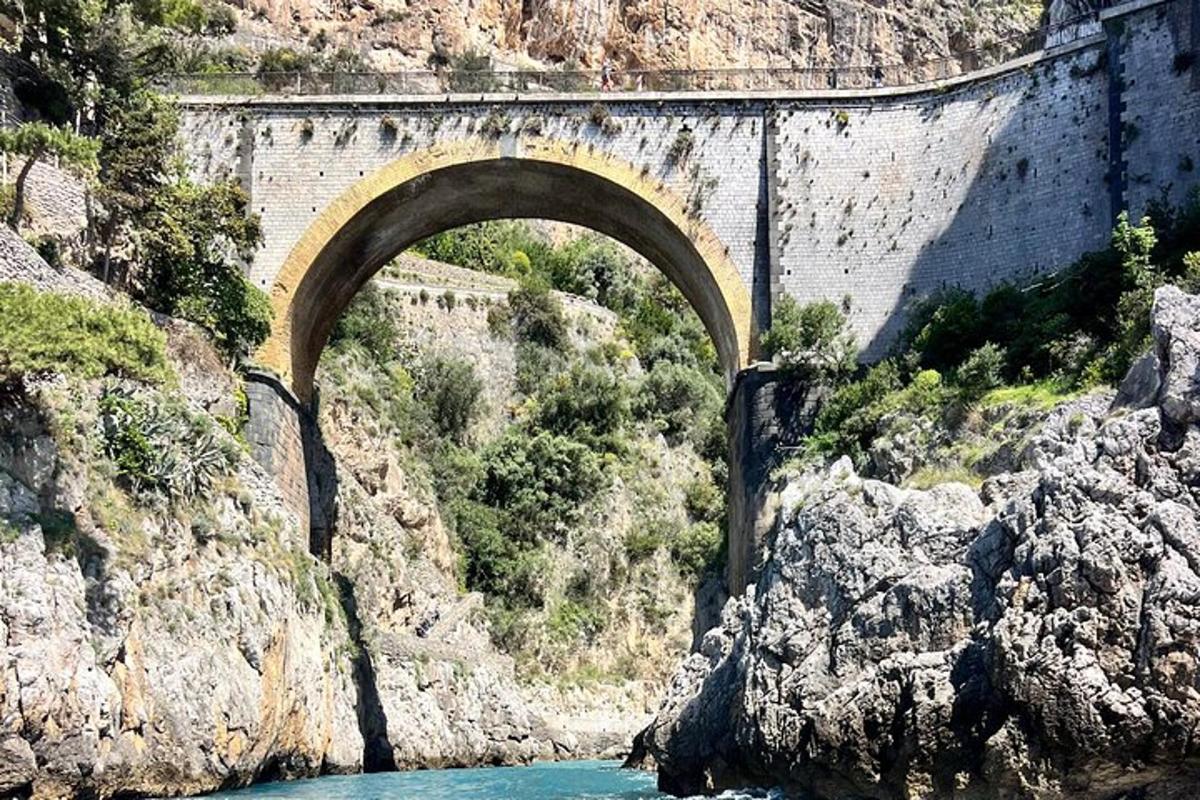 un puente sobre un río en una montaña rocosa