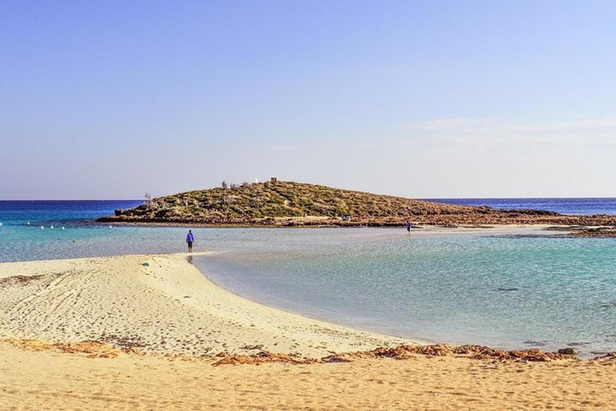 a person standing on a beach with an island in the water