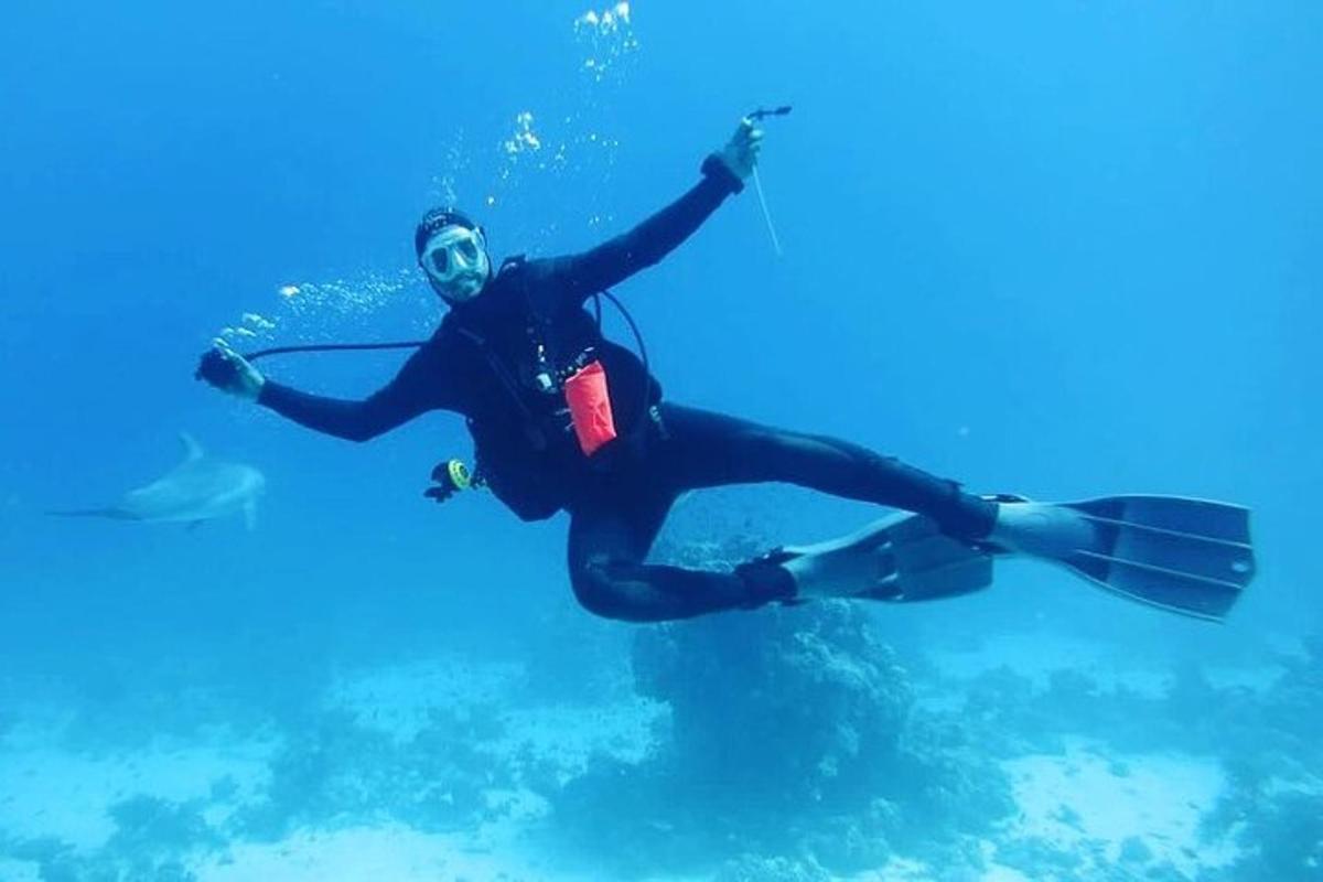 ウェットスーツを着て水中で泳ぐ男性