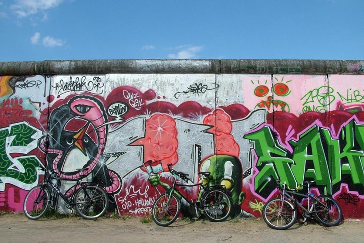 egy csoport bicikli parkolva egy graffitivel borított fal előtt