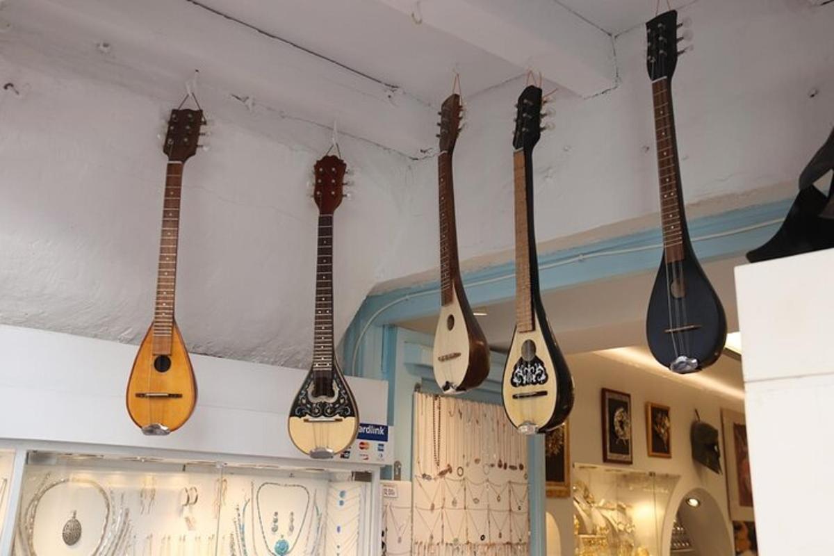egy sor akusztikus gitár lóg a falon