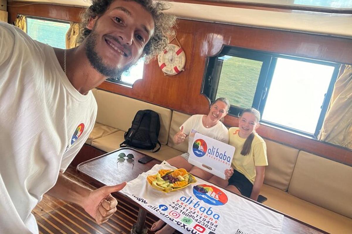 um homem segurando uma caixa de comida com duas mulheres