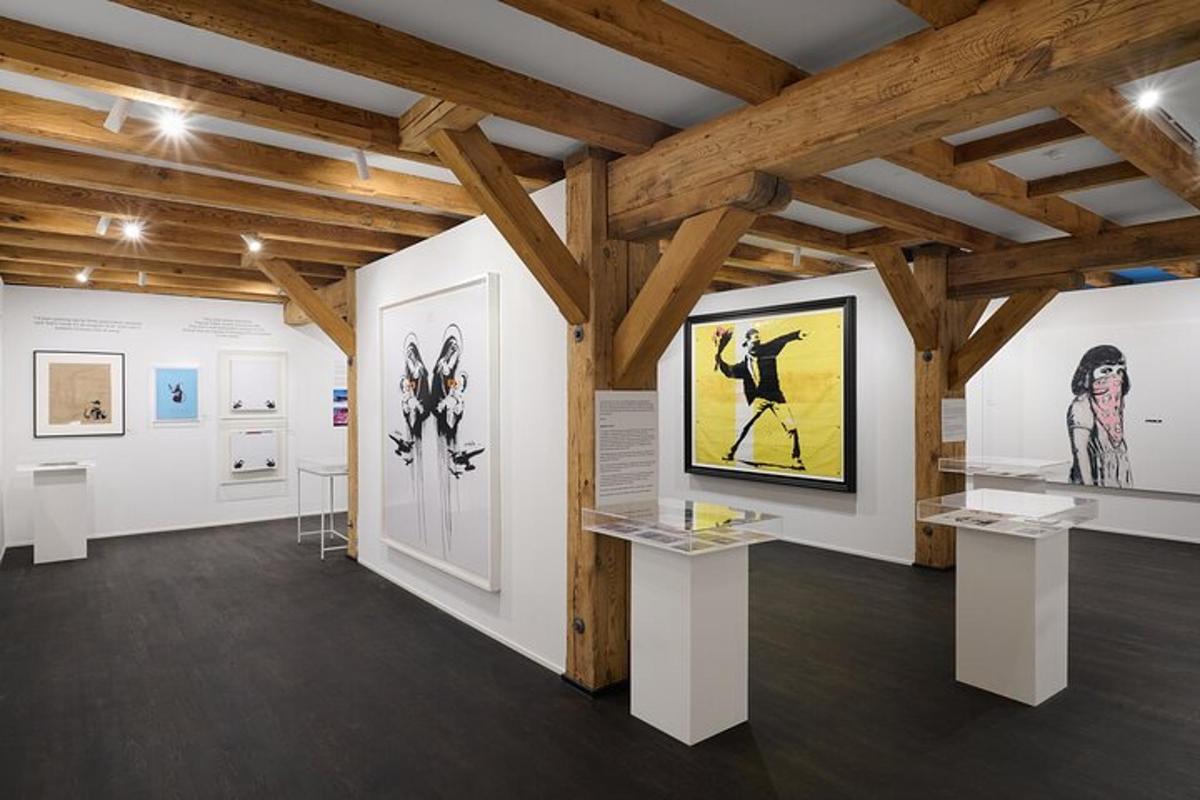 a gallery with white walls and wooden beams