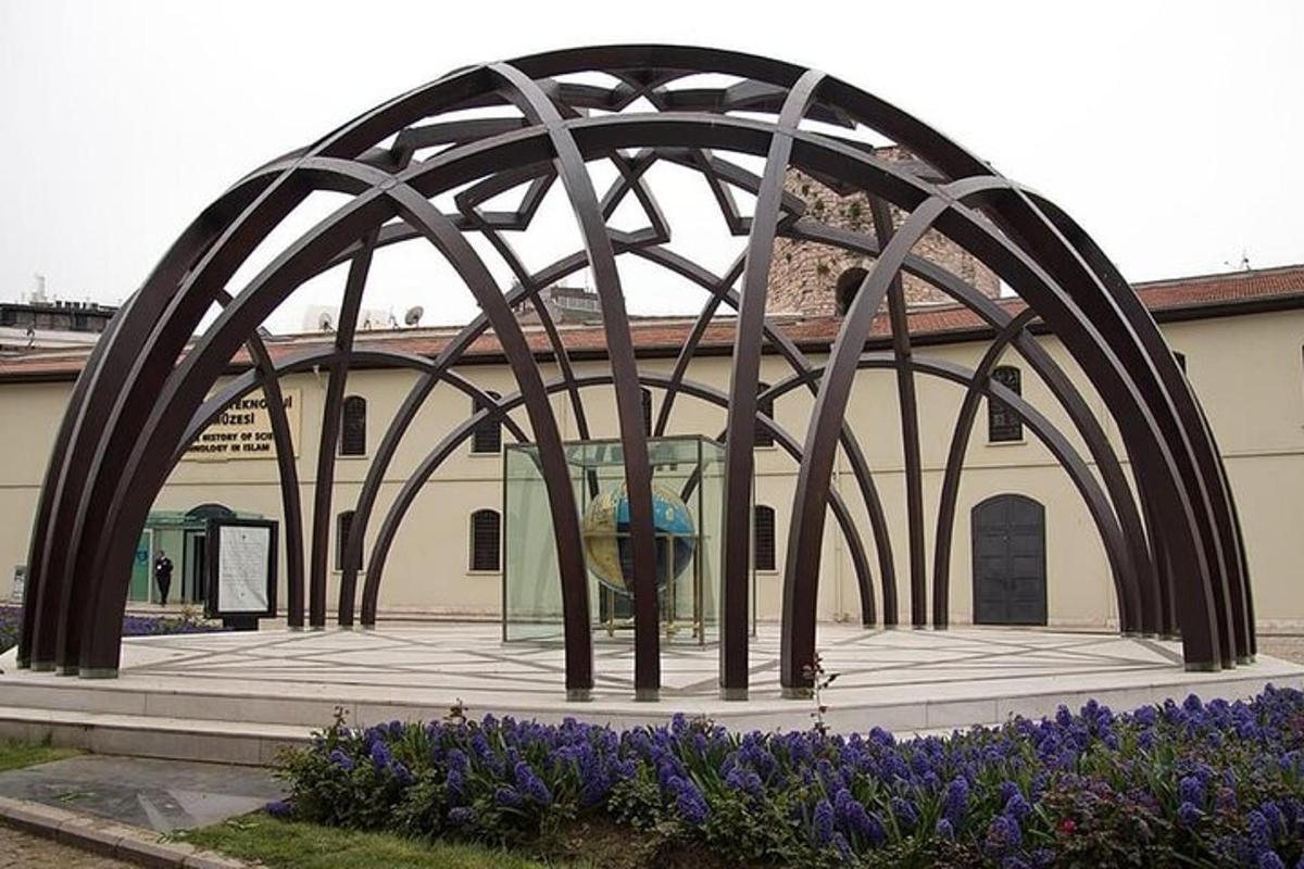 un edificio con un arco di fronte a un edificio con fiori viola