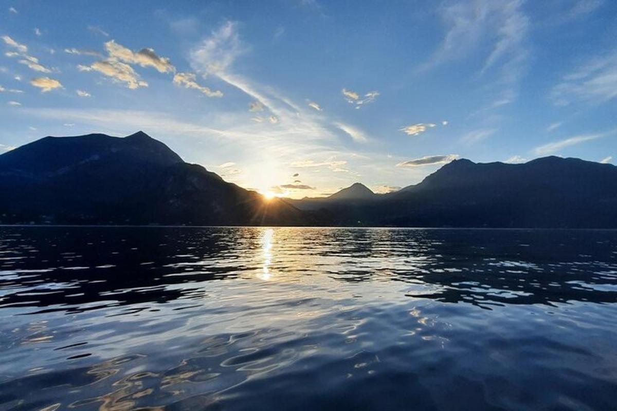 et vandområde med solen ned bag bjergene