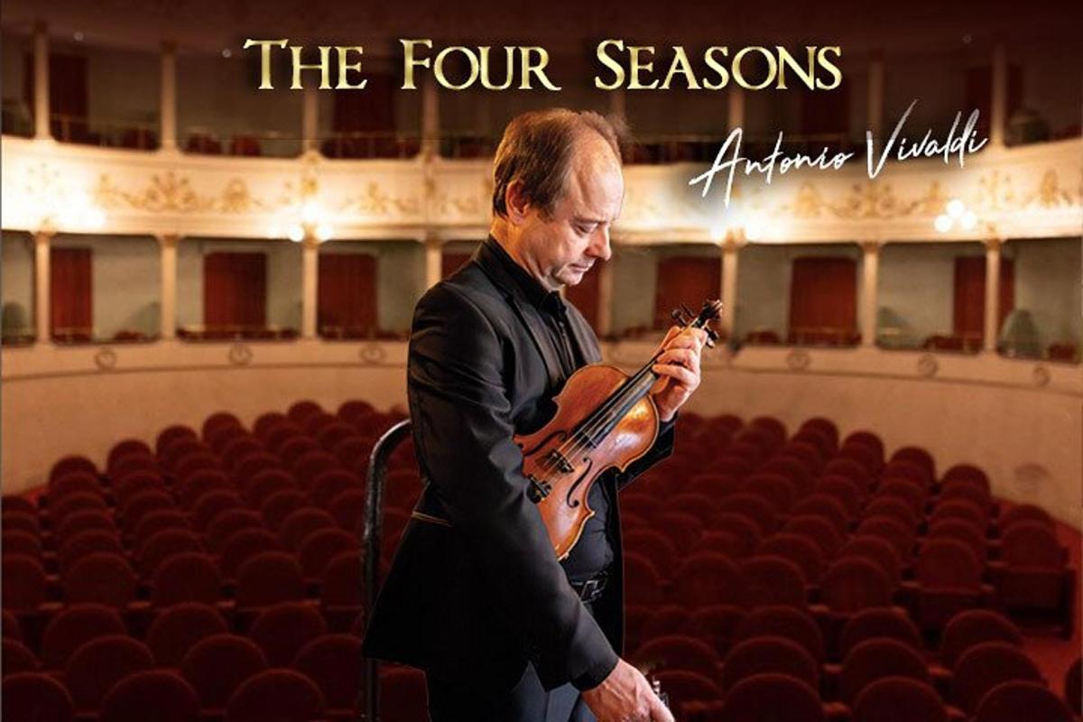 um homem tocando violino em um auditório
