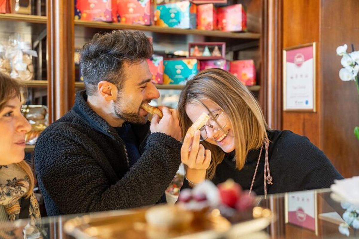 Un hombre y una mujer sentados en una mesa comiendo comida