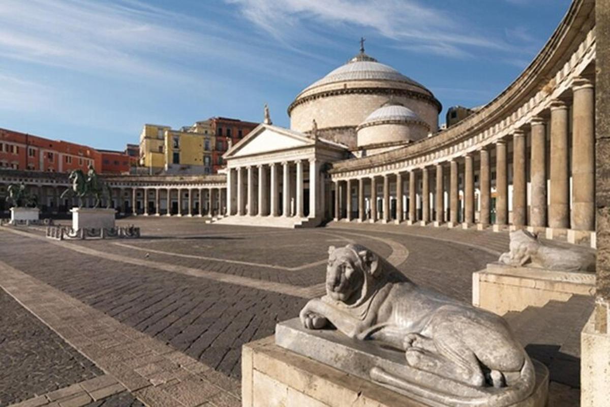 un gos estirat sobre una estàtua davant d'un edifici