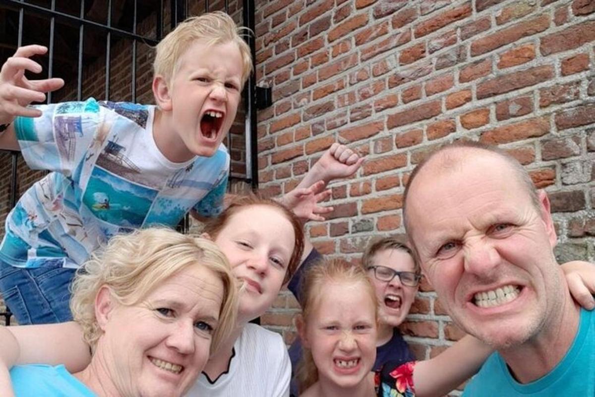 a group of people standing next to a brick wall