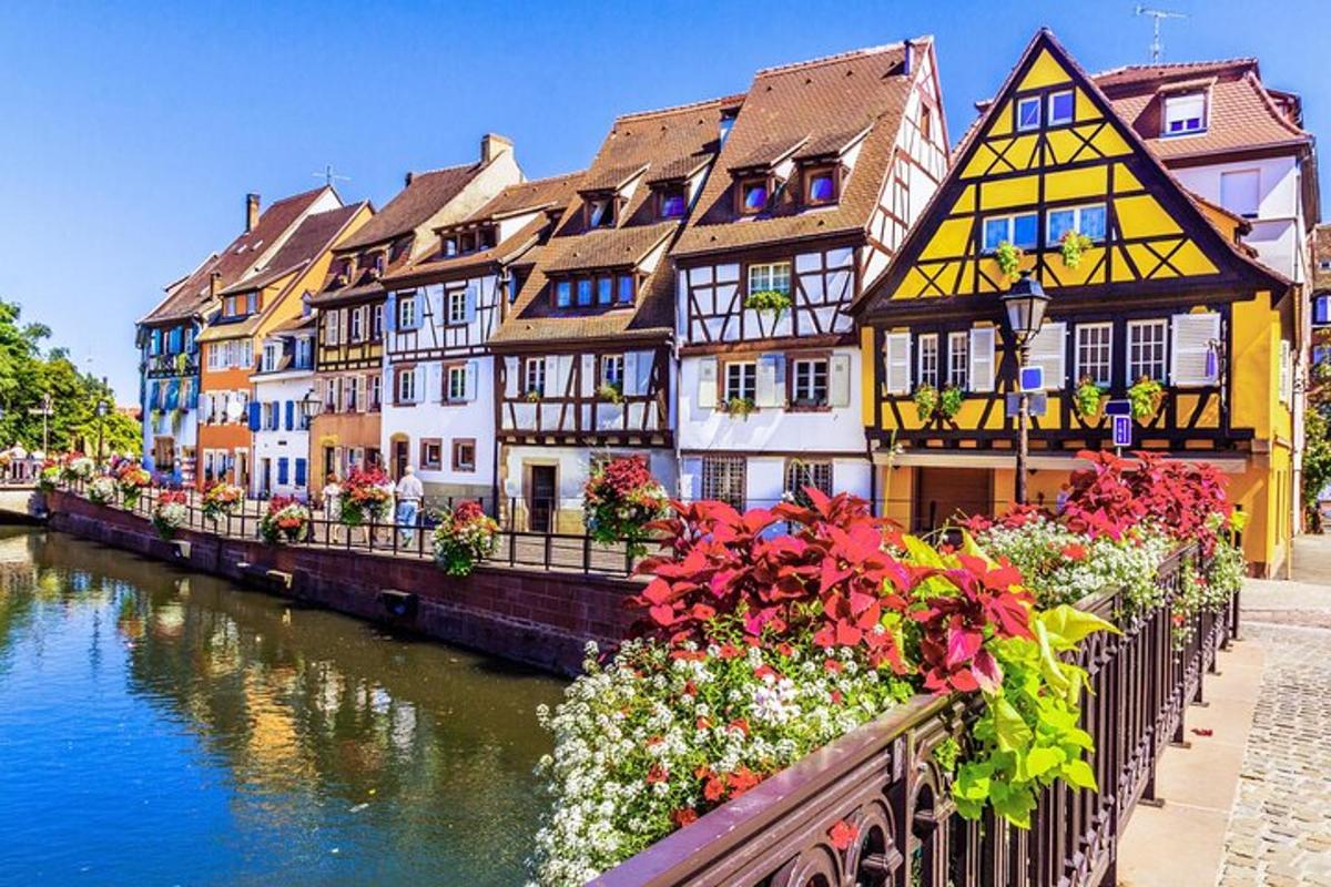 skupina budov u řeky s květinami