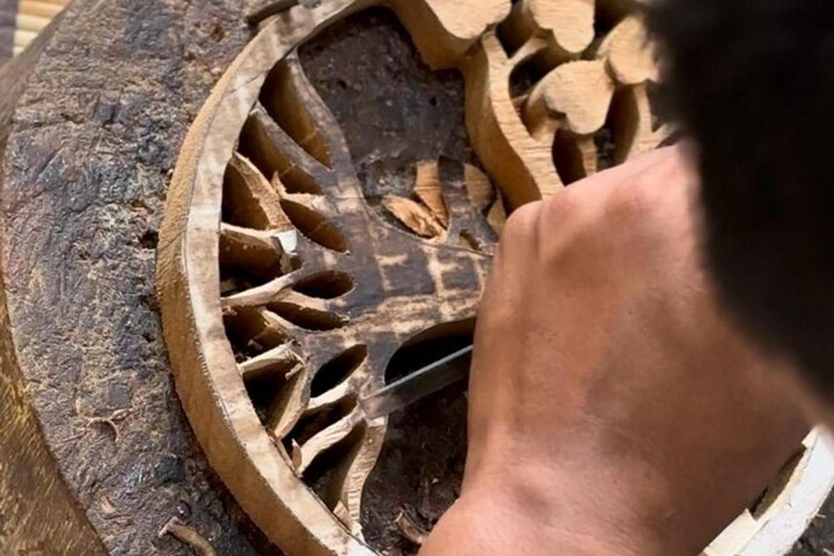 a person is looking at a wooden object on a table