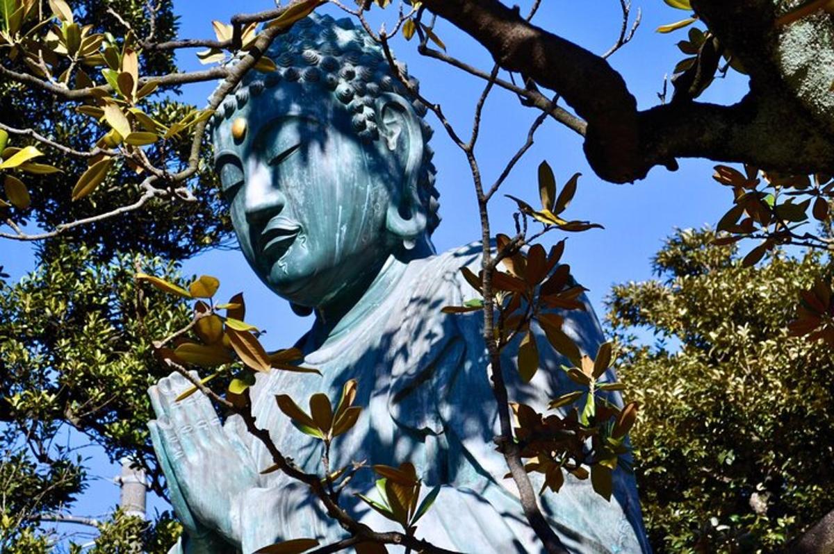uma estátua de uma mulher sentada sob uma árvore