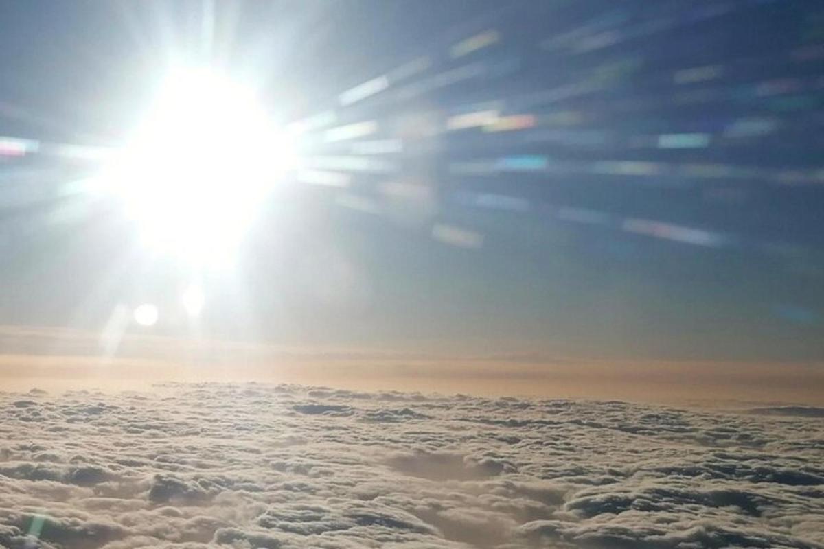 a sun is shining above the clouds in the sky