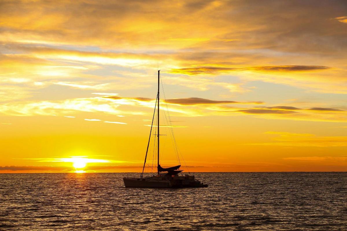 um veleiro no oceano ao pôr do sol