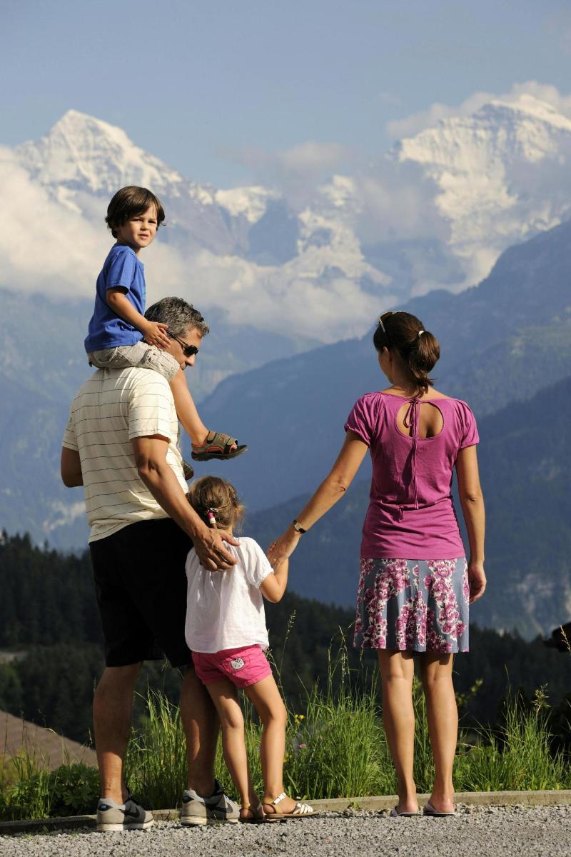 en familie som holder hender mens de står på et fjell