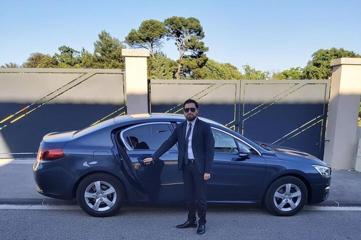 a man in a suit standing next to a blue car