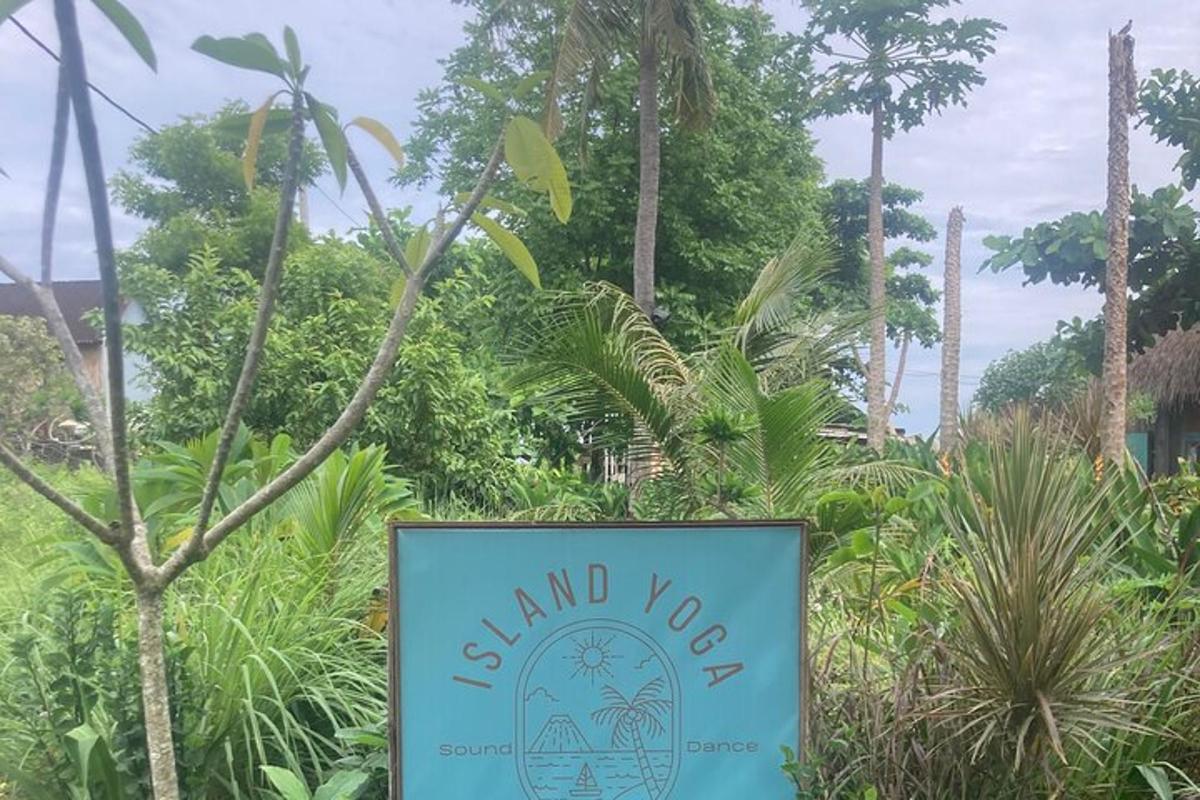 a sign in front of a garden with trees
