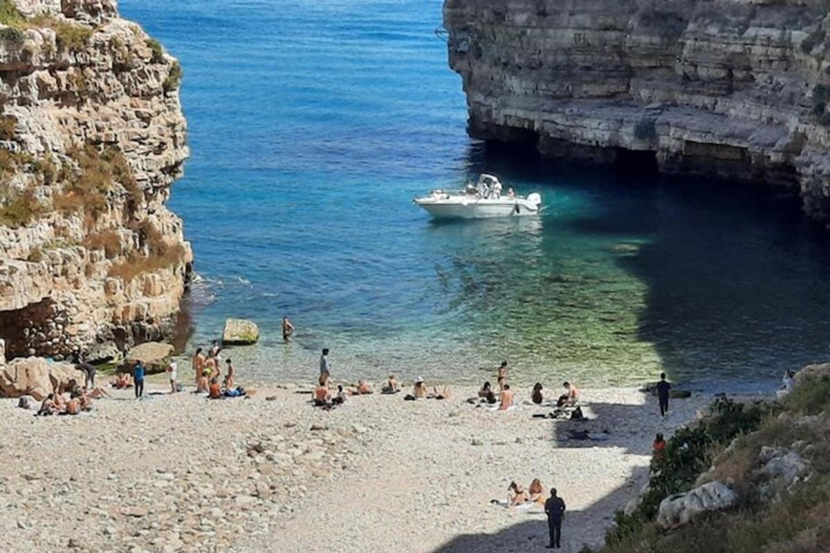 Grupa ludzi na plaży z łódką na wodzie
