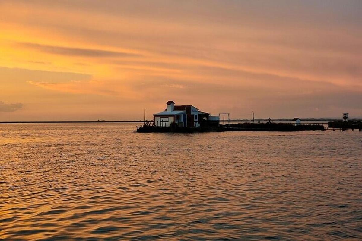 una casa en un moll a l'aigua a la posta de sol