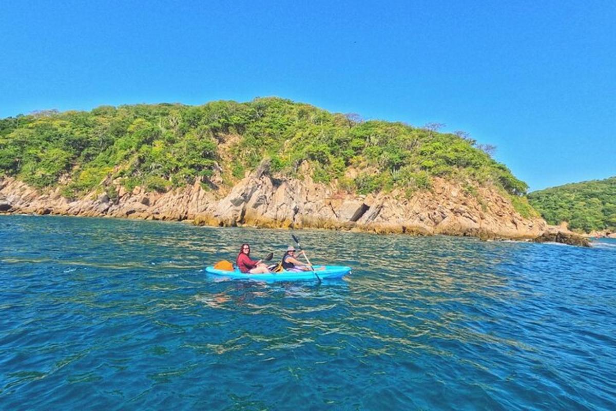 dua orang dalam kayak di dalam air berhampiran sebuah pulau